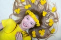 Portrait of a young girl with a wreath and yellow dandelion flowers in her loose blond hair. Beauty and flowers. View from above Royalty Free Stock Photo