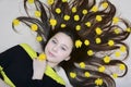 Portrait of a young girl with yellow dandelion flowers in her loose hair. View from above Royalty Free Stock Photo