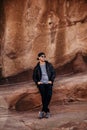 Portrait of Young Good Looking Casual Traveling Handsome Man Smiling Near Ancient Desert Red Rocks in Jacket Outside Royalty Free Stock Photo