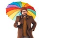Portrait of young good-looking Caucasian man in glasses and hat holding a multicoloured umbrella, holding another hand