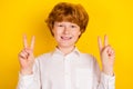 Portrait of young good mood positive lovely boy show v-sign happy go back to school isolated on yellow color background