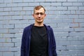 Portrait of young goodlooking man against grey brickwall. Royalty Free Stock Photo