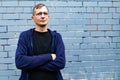 Portrait of young goodlooking man against grey brickwall. Royalty Free Stock Photo