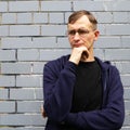 Portrait of young goodlooking man against grey brickwall. Royalty Free Stock Photo