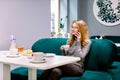 Portrait of young gorgeous female drinking tea and looking with smile out of the coffee shop window while enjoying her Royalty Free Stock Photo