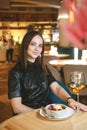 Portrait of young gorgeous woman drinking champagne in a glass and looking with smile, eating ice cream fruit dessert. Royalty Free Stock Photo