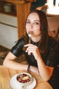 Portrait of young gorgeous woman drinking champagne in a glass and looking with smile, eating ice cream fruit dessert. Royalty Free Stock Photo