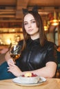 Portrait of young gorgeous woman drinking champagne in a glass and looking with smile, eating ice cream fruit dessert. Royalty Free Stock Photo