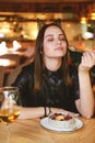 Portrait of young gorgeous woman drinking champagne in a glass and looking with smile, eating ice cream fruit dessert. Royalty Free Stock Photo