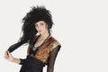 Portrait of young Goth woman with teased hair over gray background Royalty Free Stock Photo