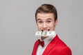 Portrait of young greedy businessman holding dollar banknote with teeth, grinning, money-hungry