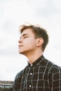 Portrait of young guy, brunette with dark hair, Caucasian. Close - up of a guy, boy, man looking past camera. Outdoor in city by Royalty Free Stock Photo