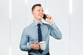 Portrait of young guy businessman dressed in blue shirt and tie, talking on the mobile phone Royalty Free Stock Photo