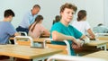 Portrait of young guy student in audience, looking at camera