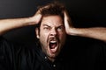 Portrait of young guy who grabs his head in hands