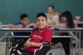 Portrait of young handicapped kid boy sitting on wheelchair and looking to camera with happiness eyes Royalty Free Stock Photo