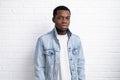 Portrait young handsome african black man wearing denim jeans jacket against brick with wall outdoors with copyspace. Royalty Free Stock Photo