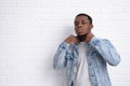 Portrait young handsome african black man wearing denim jeans jacket against brick with wall outdoors with copyspace. Royalty Free Stock Photo