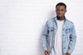 Portrait young handsome african black man wearing denim jeans jacket against brick with wall outdoors with copyspace. Royalty Free Stock Photo