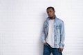 Portrait young handsome african black man wearing denim jeans jacket against brick with wall outdoors with copyspace. Royalty Free Stock Photo