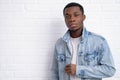 Portrait young handsome african black man wearing denim jeans jacket against brick with wall outdoors with copyspace. Royalty Free Stock Photo