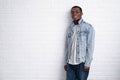 Portrait young handsome african black man wearing denim jeans jacket against brick with wall outdoors with copyspace. Royalty Free Stock Photo