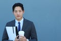 Portrait of a young handsome Asian man businessman in black classic suit with trendy blue tie. Close up of a coffee break Royalty Free Stock Photo