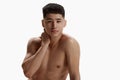 Portrait of young, handsome, asian man with clear spotless face posing shirtless against white studio background Royalty Free Stock Photo