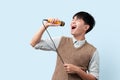 Portrait of young handsome Asian man singing a song with a microphone Royalty Free Stock Photo