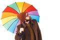 Portrait of young handsome bearded Caucasian man holding a multicoloured umbrella and looking up at the sky weather