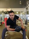 Full body shot of young bearded Indian man lifting weights at the gym Royalty Free Stock Photo