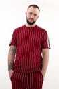 Portrait of young handsome bearded man with short dark hair wearing red striped sport wear, looking at camera, posing. Royalty Free Stock Photo