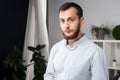 Portrait of a young handsome Caucasian brunette man with a beard. 20-25 years old standing in plaid shirt. Hands folded on his Royalty Free Stock Photo