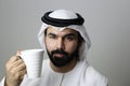 Portrait Of A Young Confident Arab Businessman Wearing UAE Emirati Tradational Dressn Holding A Mug  ARAB EMIRATI MODEL Royalty Free Stock Photo