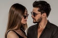 Portrait of young handsome couple wearing fashionable sunglasses, looking at eachother. Bearded man posing with beautiful woman Royalty Free Stock Photo