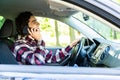 Portrait of young handsome man driving car and speaking on mobile phone Royalty Free Stock Photo