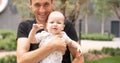 Portrait of young handsome father holding his adorable cute newborn baby boy. Lifestyle. Real people. Fatherhood and Royalty Free Stock Photo