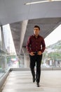 Handsome Hispanic businessman walking and thinking on the footbridge Royalty Free Stock Photo