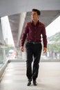 Young handsome Hispanic businessman thinking and walking on the footbridge Royalty Free Stock Photo