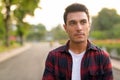 Face of young thoughtful Hispanic hipster man at the park Royalty Free Stock Photo