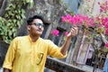 Portrait of a young and handsome Indian Bengali man standing in front of a vintage house wearing green Indian traditional Punjabi