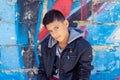 Portrait of a young handsome italian boy posing in the city urban graffiti background Royalty Free Stock Photo