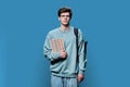 Portrait of young male college student in glasses with backpack on blue background Royalty Free Stock Photo