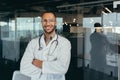 Portrait of a young handsome male hispanic doctor. Standing in the glass hall of the hospital Royalty Free Stock Photo