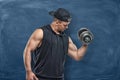 Portrait of young handsome man in black outfit standing and showing his muscled biceps during training Royalty Free Stock Photo