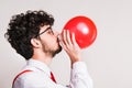 Portrait of a young man with balloon in a studio. Royalty Free Stock Photo