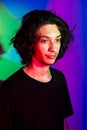 Portrait of young handsome man with colorful shadows on photographic background