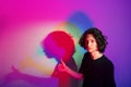 Portrait of young handsome man with colorful shadows on photographic background