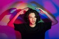 Portrait of young handsome man with colorful shadows on photographic background