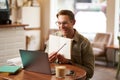 Portrait of young handsome man in glasses, private tutor teaching student online, pointing at his notebook, showing Royalty Free Stock Photo